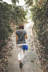 Woman with luxury snakeskin python handbag in the tropical forest. Bali island.