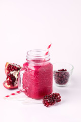 Healthy Detox Smoothies on a White Background With Berry and Pomegranate Glass Jar of Tasty Smoothie Vertical