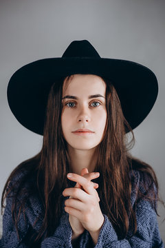 Calm and mysterious portrait of beautiful young  woman wearing  black hat .