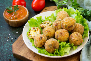 Arancini - traditional Italian Rice Balls with Mozzarella and Sun-dried tomatoes, served with tomato sauce.