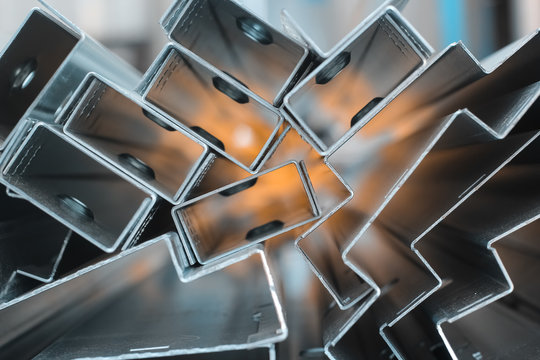 Focused Blurred Background for steel sheet metal profiles. a Stell Zinc coated profiles in the rack in artistic blurry organe background. In focus version