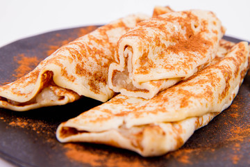 Pancakes stuffed with braised apples sprinkled with cinnamon