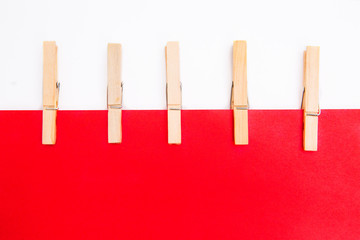 Wooden clothespins with red paper on white background. Isolated on white. Template