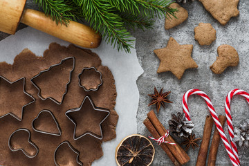 Ingredients for cooking Christmas gingerbread cookies with fir tree and decorations on stone background, top view