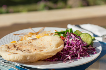 Salad and scrambled eggs in a white plate
