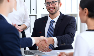 Business handshake at meeting or negotiation in the office. Two businessmen partners are satisfied because signing contract or financial papers