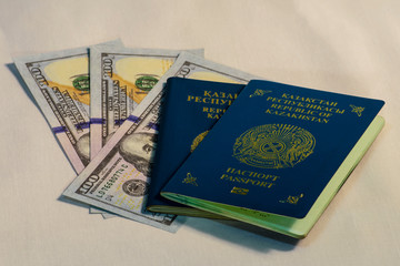 Two passports of a citizen of the Republic of Kazakhstan are on dollar bills.