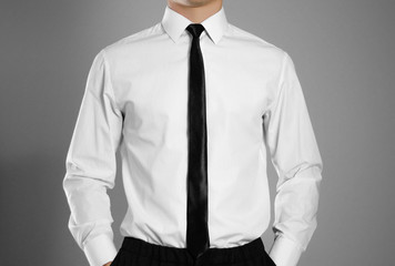 Businessman in a white shirt and tie holding hands in his pockets. Isolated background