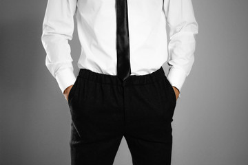 Businessman in a white shirt and tie holding hands in his pockets. Isolated background