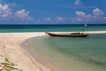 Traditional thai long boat moored at a beach