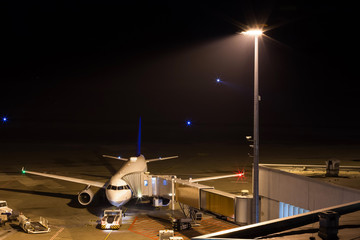 an airplane at night at an airport gate