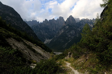 Fototapeta na wymiar Stretta valle alpina con picchi montuosi sullo sfondo - Valle Cimolaia - Parco naturale delle Dolomiti Friulane - Italia