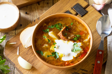 Traditional Ukrainian Russian borscht. Borsch, Soup with Sour Cream in bowl on kitchen wooden table.