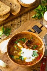 Traditional Ukrainian Russian borscht. Borsch, Soup with Sour Cream in bowl on kitchen wooden table.