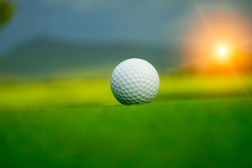 golf ball on green in beautiful golf course with sunset