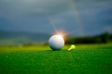 Golf ball on green in beautiful golf course at sunset background.