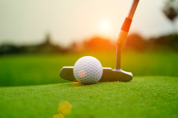 Blurred golf ball and golf club in beautiful golf course at sunset background.
