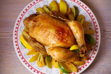 Сhicken with potatoes, lemons and limes on the table with festive Christmas and New Year decorations. View from above, top