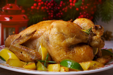 Сhicken with potatoes, lemons and limes on the table with festive Christmas and New Year decorations