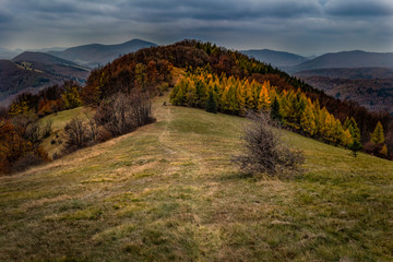 Naklejka na ściany i meble Mountain landscape in autumn.Mountain forest landscape under evening sky with clouds in sunlight.Natural outdoor travel background.Autumn mountain landscape in Slovakia.