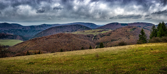 Fototapeta premium Mountain landscape in autumn.Mountain forest landscape under evening sky with clouds in sunlight.Natural outdoor travel background.Autumn mountain landscape in Slovakia.