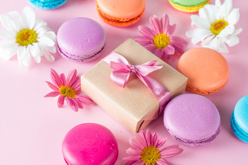 Fototapeta na wymiar Photo of cake macarons, gift box, tea, coffee, cappuccino and flowers. Sweet romantic food macaroon concept. Morning breakfast and presents. Valentine's day concept.