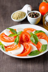 Close-up photo of caprese salad with ripe tomatoes, basil, buffalo mozzarella cheese. Italian and Mediterranean food concept. Fresh and healthy organic meal. Starter and antipasti. 
