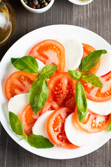 Close-up photo of caprese salad with ripe tomatoes, basil, buffalo mozzarella cheese. Italian and Mediterranean food concept. Fresh and healthy organic meal. Starter and antipasti. 