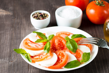 Close-up photo of caprese salad with ripe tomatoes, basil, buffalo mozzarella cheese. Italian and Mediterranean food concept. Fresh and healthy organic meal. Starter and antipasti. 
