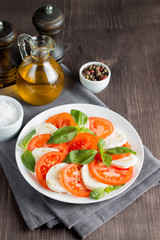 Close-up photo of caprese salad with ripe tomatoes, basil, buffalo mozzarella cheese. Italian and Mediterranean food concept. Fresh and healthy organic meal. Starter and antipasti. 