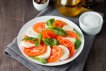Close-up photo of caprese salad with ripe tomatoes, basil, buffalo mozzarella cheese. Italian and Mediterranean food concept. Fresh and healthy organic meal. Starter and antipasti. 