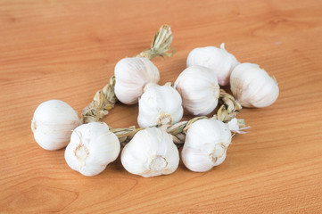 Polish garlic bulbs at wooden table.
