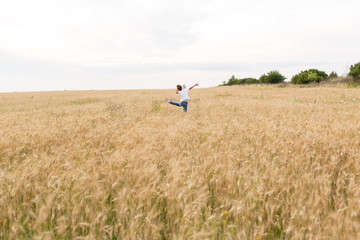 Naklejka na ściany i meble the guy jumps . boy in wheat field. child. wheat field