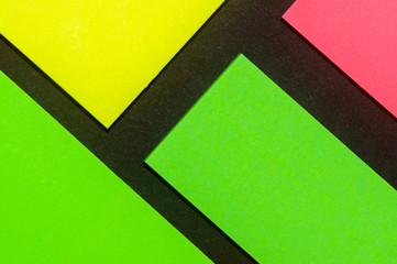 Green, yellow and rose hue colorful office stickers on black paper. Office noteparer as reminder....