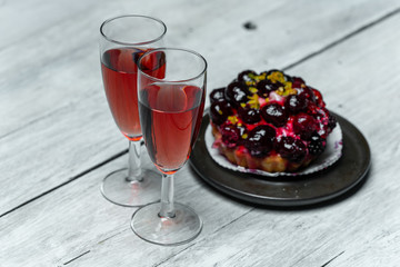 sweet meal for two: red wine and cake with icing and fruits