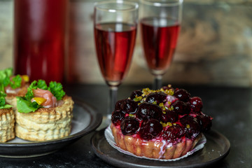sweet meal for two: red wine, cake with icing and fruit, French patties