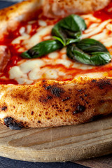 close up of Italian Pizza in chopping board on a wooden table