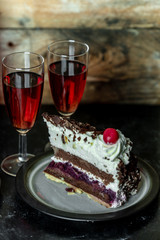 sweet meal for two: red wine and chocolate cake with cherry and whipped cream