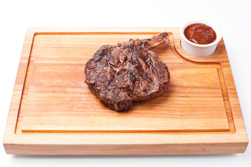 Grilled meat with sauce on wood board. white background.