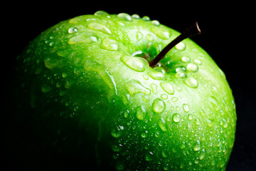 ripe green apple on black background