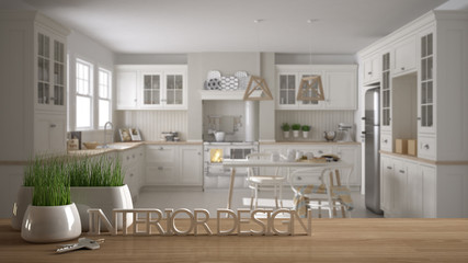 Wooden table, desk or shelf with potted grass plant, house keys and 3D letters making the words interior design, over scandinavian kitchen with dining table, project concept background