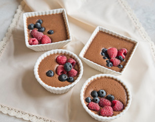 Chocolate dessert with berries on the background of a beautiful beige napkin
