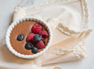 Chocolate dessert with berries on the background of a beautiful beige napkin