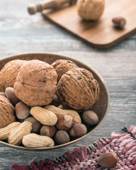 Walnuts, peanuts, hazelnuts on a vintage plate.