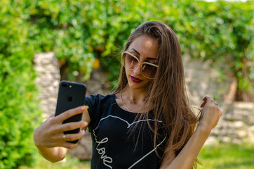 young woman in the park making selfie