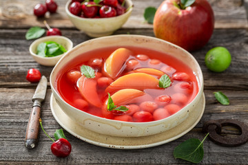 Sweet fruit soup with cherries, apples and mint