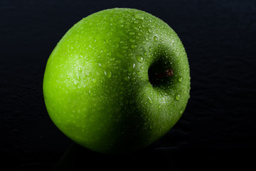 ripe green apple on black background