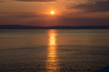 Sunset above sea wtih clouds and red heaven