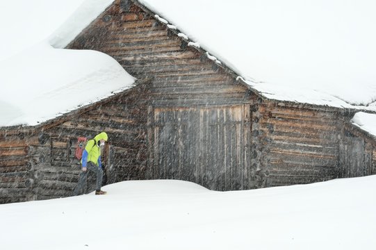 Escursionista sotto una nevicata in Val di Funes