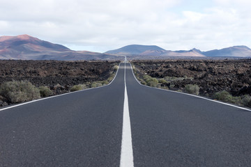 Endless highway through the volcanic landscape. Lanzarote. Canary islands. Spain